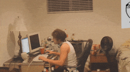 Un homme au look décontracté s'énerve devant son ordinateur, balance son clavier et frappe l’écran.